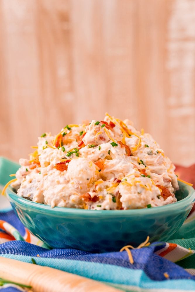 ranch potato salad in a blue bowl on a colorful towel