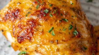 A plate of baked ranch chicken with parsley on it.