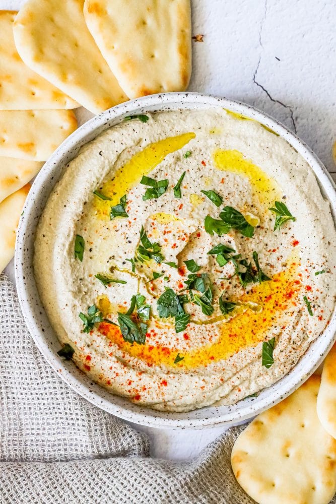 picture of baba ganoush eggplant dip in a dish with a pita dipping into it
