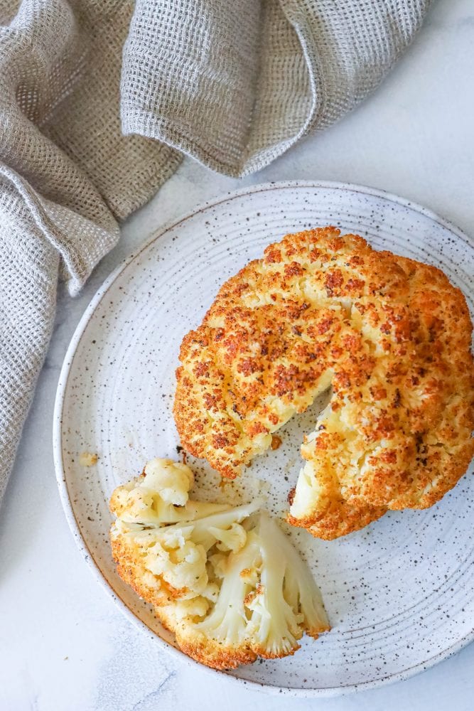 whole roasted cauliflower head on a plate