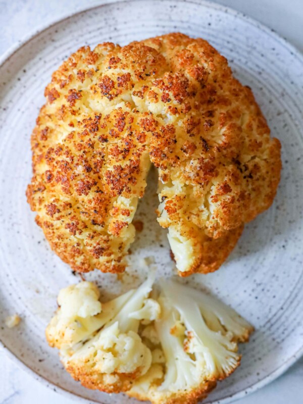 A bitten cauliflower on a plate tells the story of a whole roasted masterpiece.