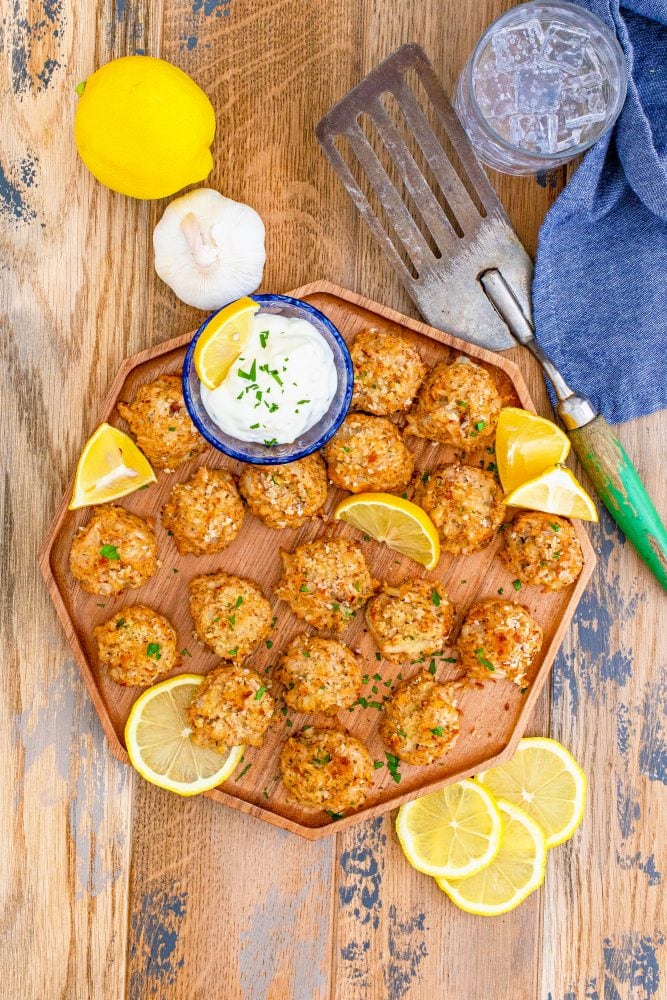 picture of crab cakes on a platter with lemon slices and tartar sauce