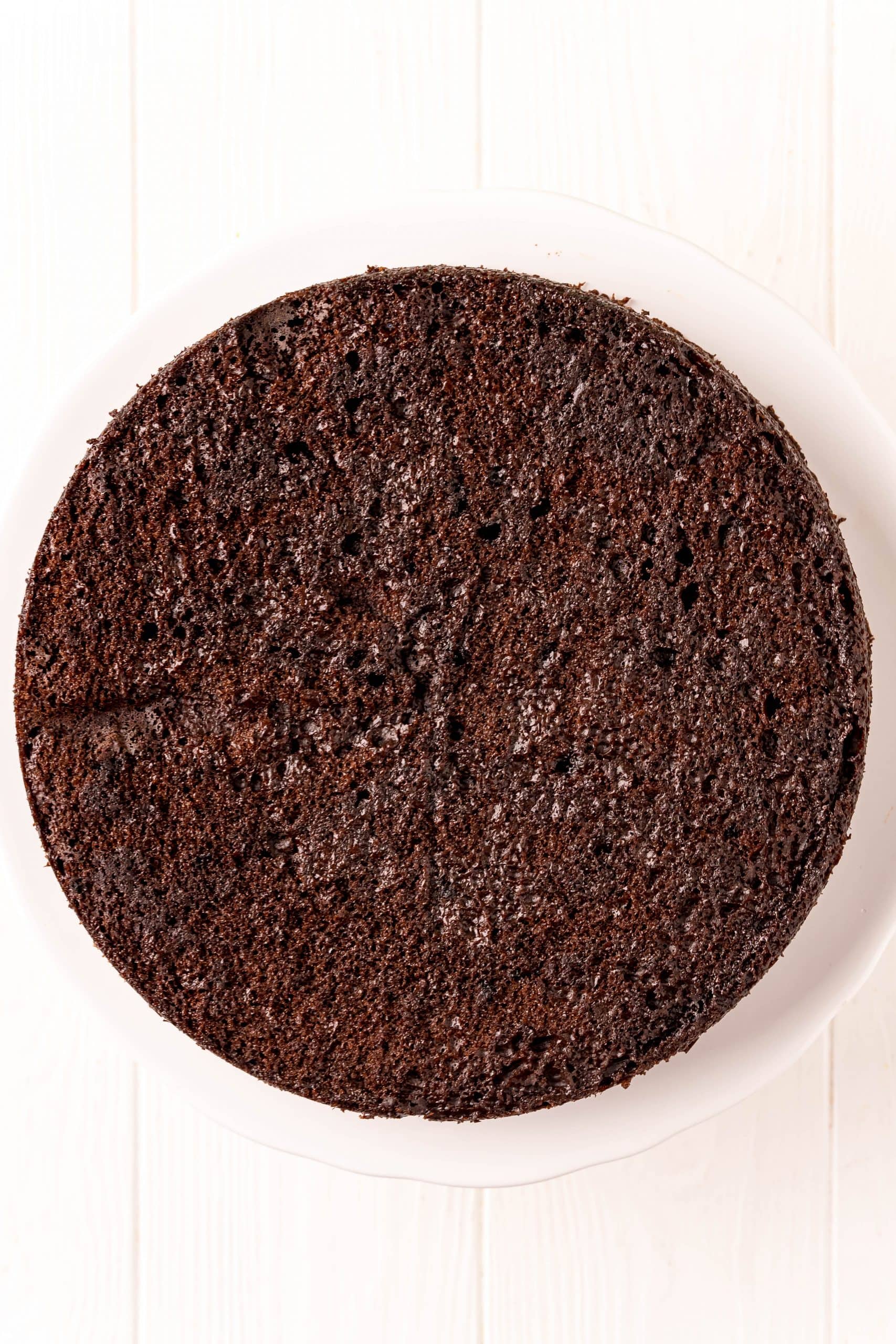 The Best chocolate cake is sitting on a white plate.
