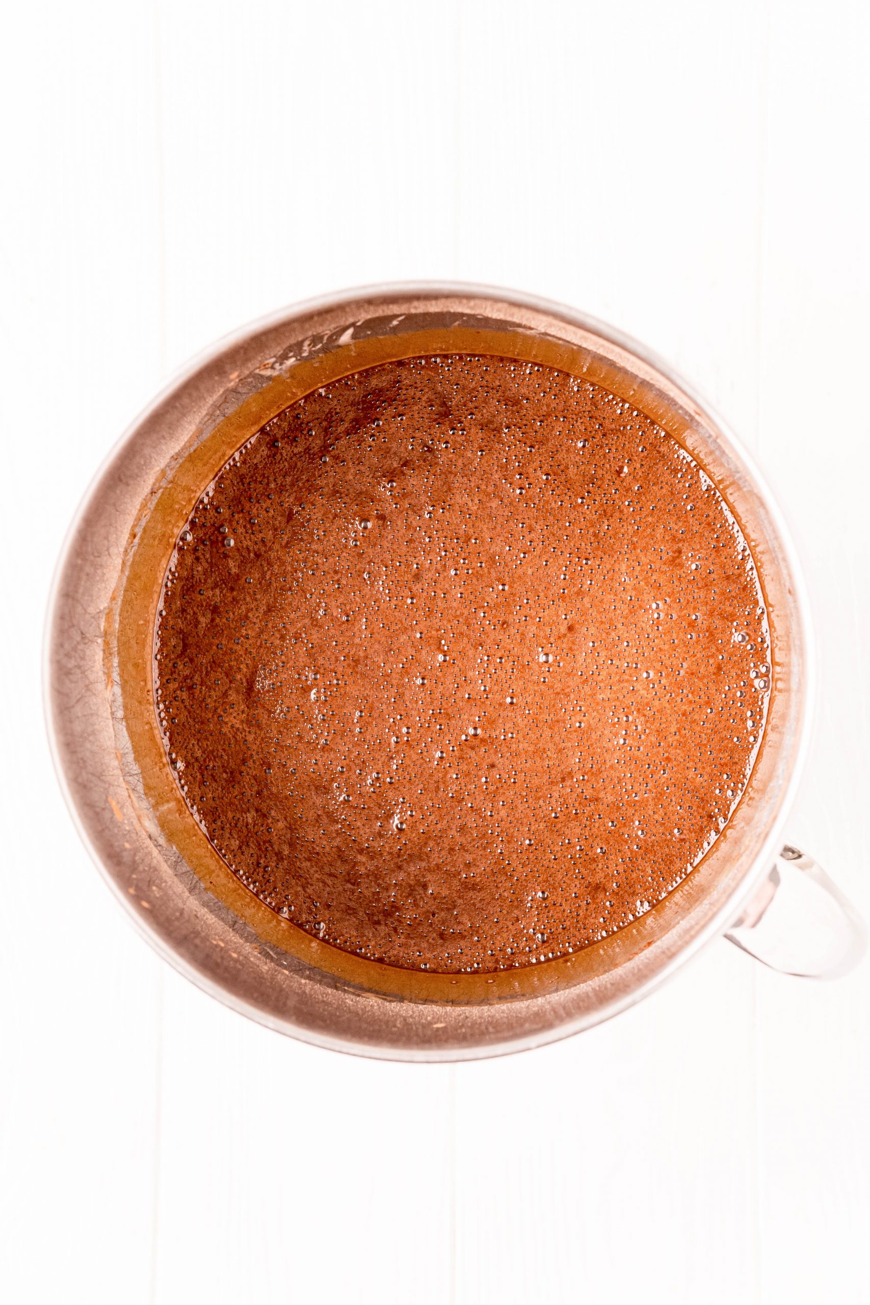 An easy recipe for the best chocolate cake baked in a metal pan with a brown liquid batter.