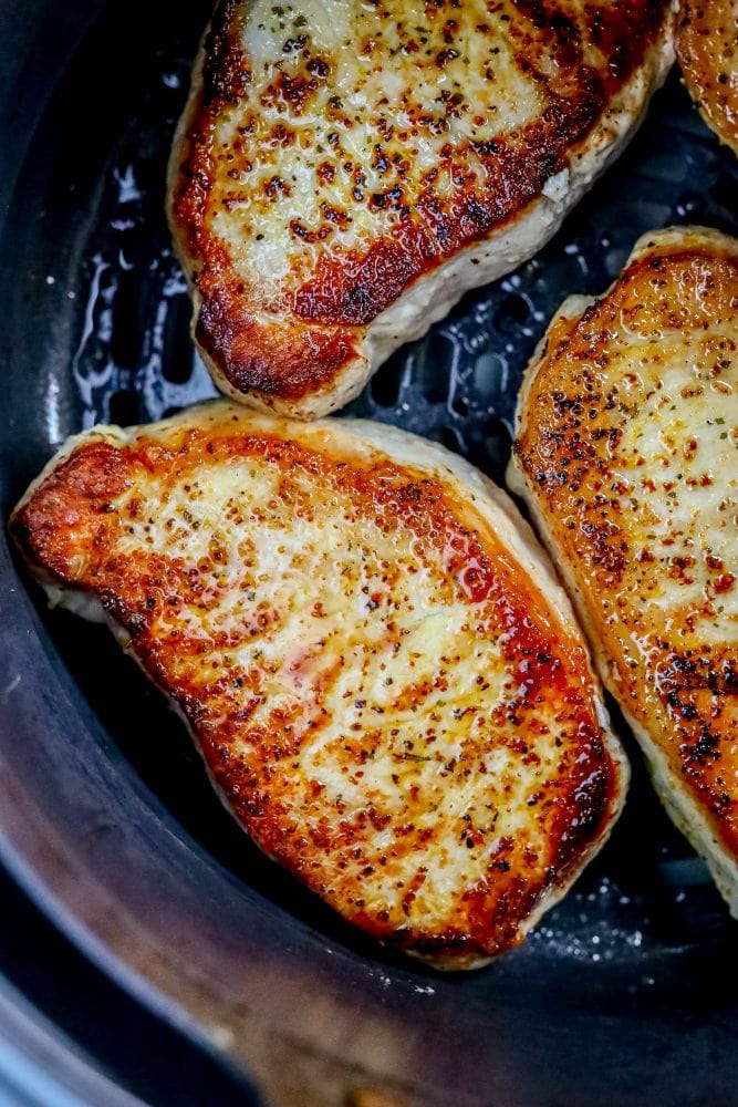 picture of pork chops in an air fryer basket