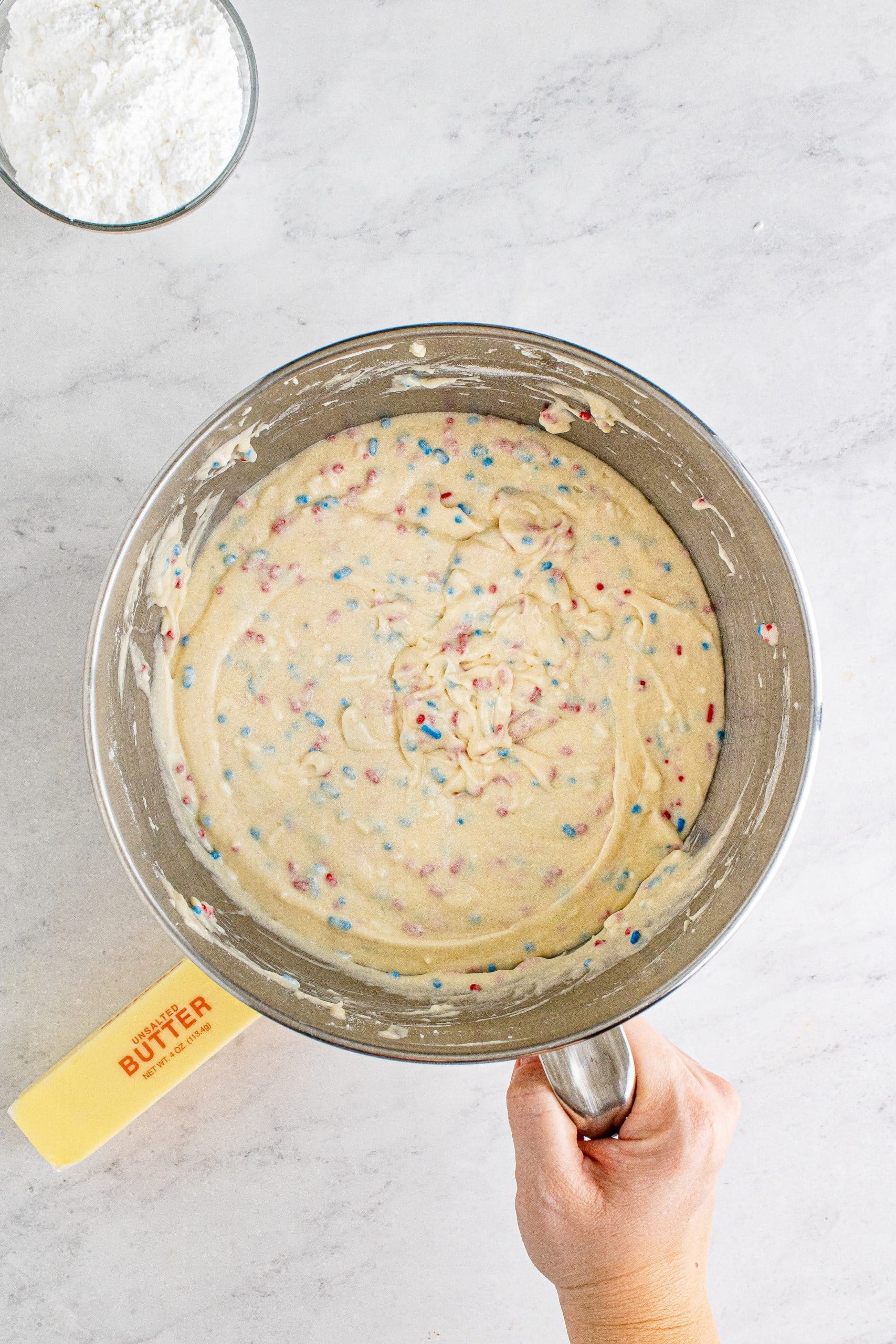 red white and blue funfetti cake batter in a bowl