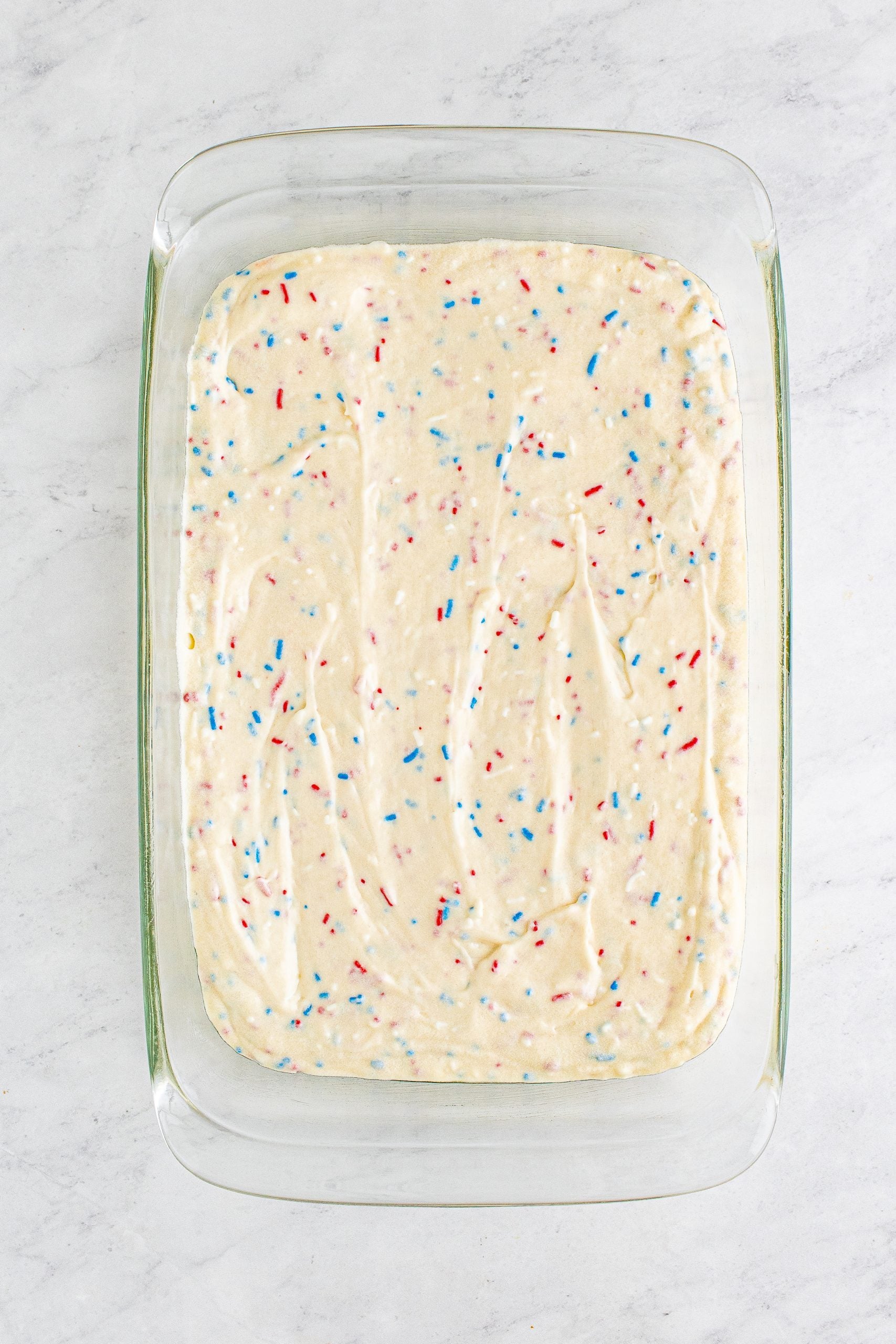 red white and blue funfetti cake batter in a cake pan
