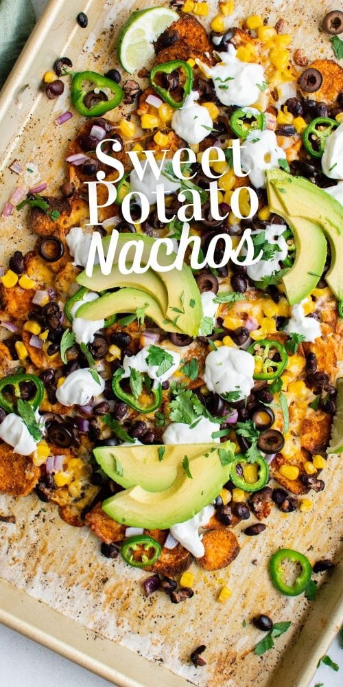 picture of sweet potato chip nachos on a plate with jalapenos, beans, corn, cheese, sour cream, avocados, and sliced limes