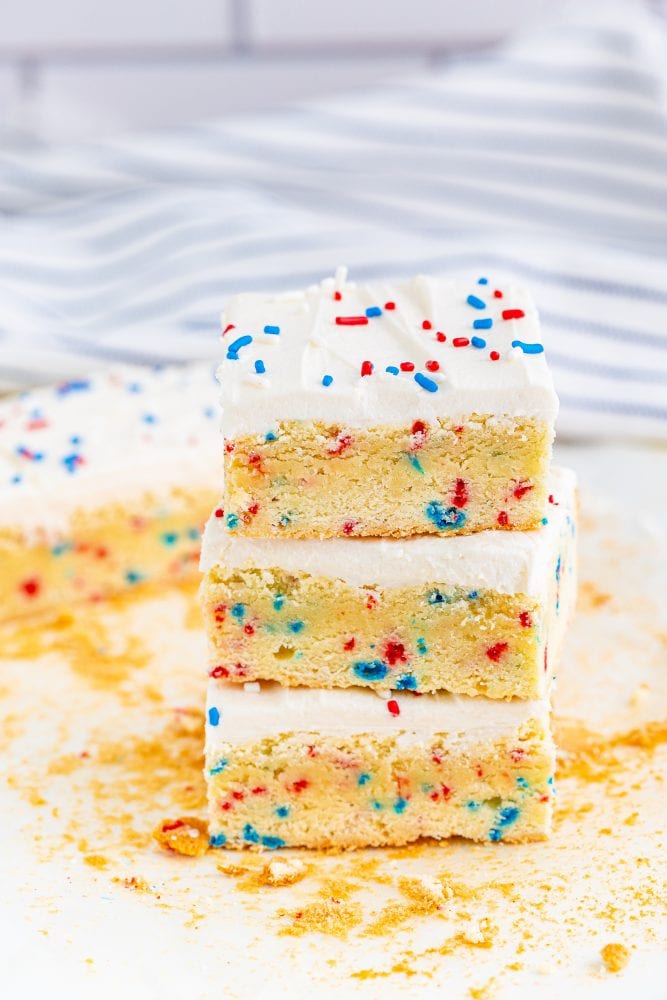 three vanilla bars with red and blue sprinkles in them and on frosting on top