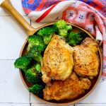 Chicken and broccoli in a keto-friendly bowl on a wooden table.