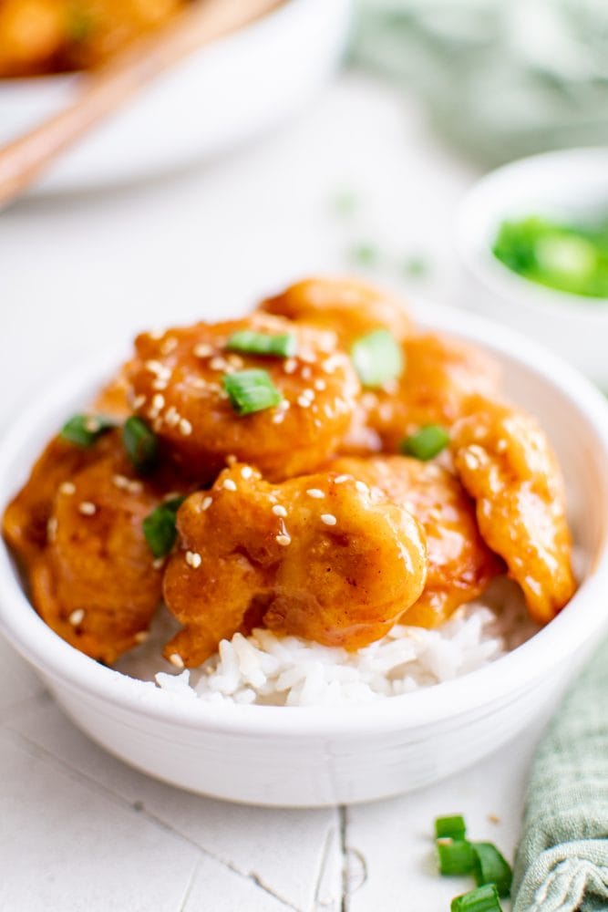picture of sesame chicken in a bowl over rice
