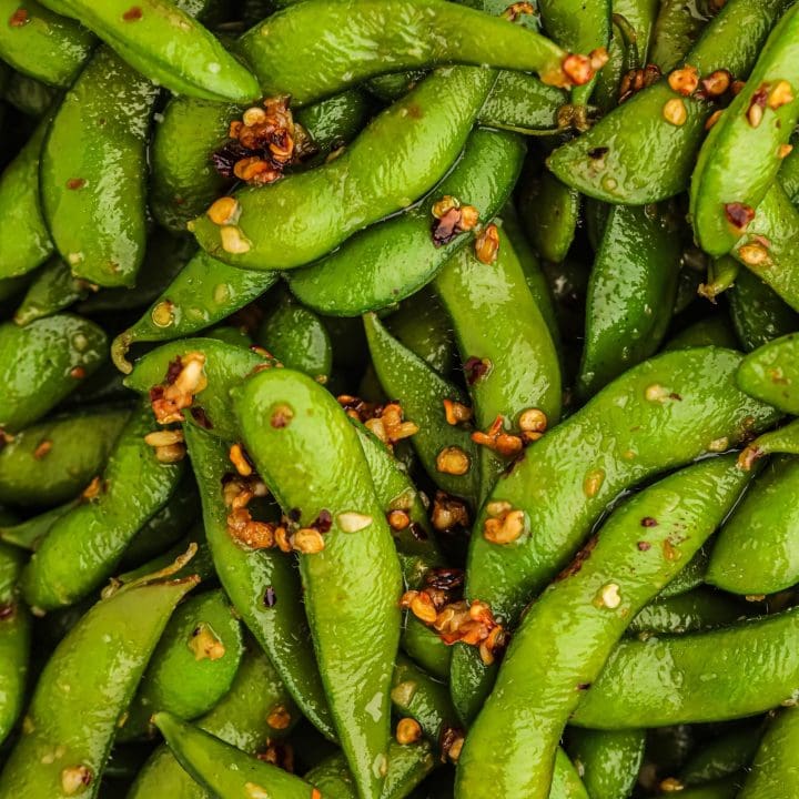 A close up of green peas sprinkled with sesame seeds, perfect for an easy edamame recipe.