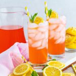 Two glasses of pink lemonade with lemon slices and mint.