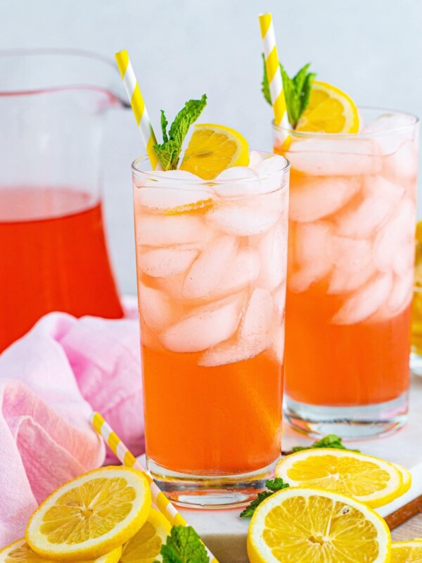 Two glasses of pink lemonade with lemon slices and mint.