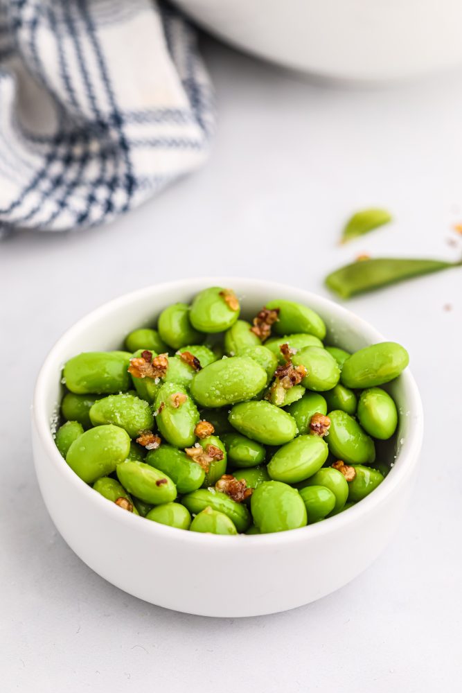 edamame beans in a bowl with spices on it. 