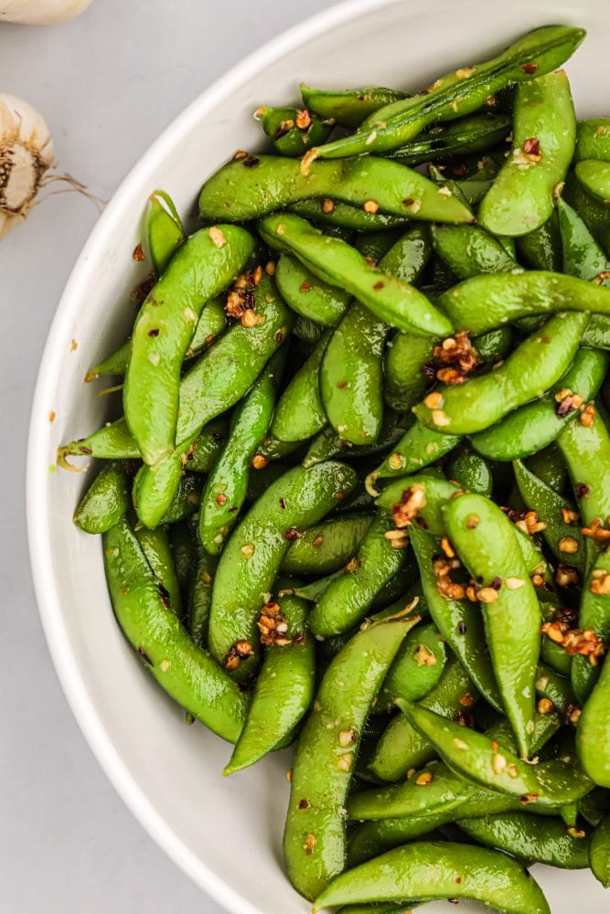 edamame beans in a bowl with spices on it. 