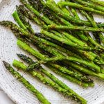 Grilled asparagus on a white plate with air fried asparagus recipe.