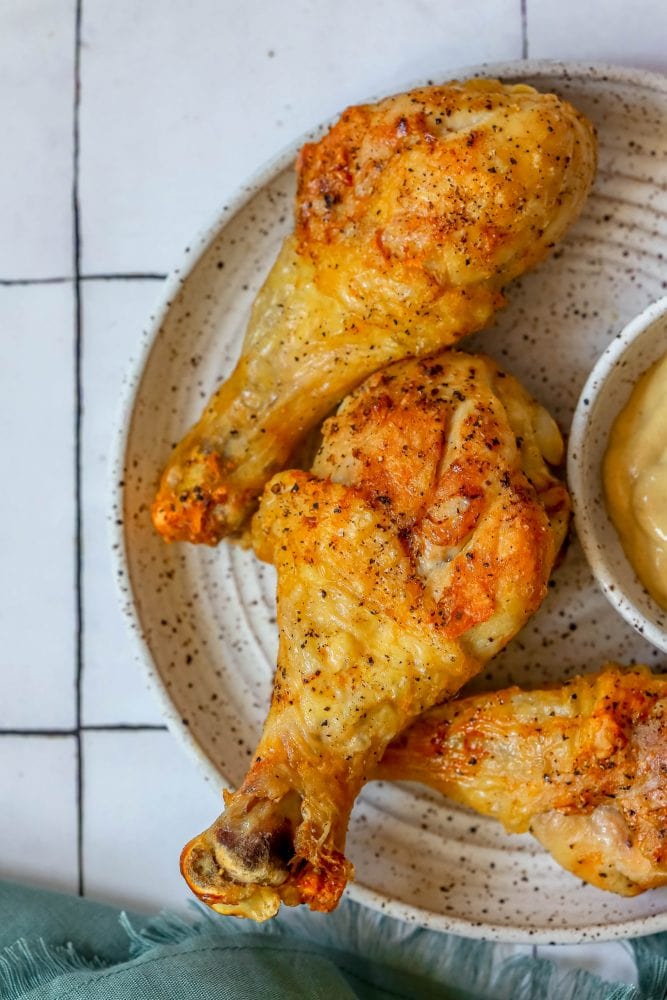 picture of air fryer chicken drumsticks on a white plate