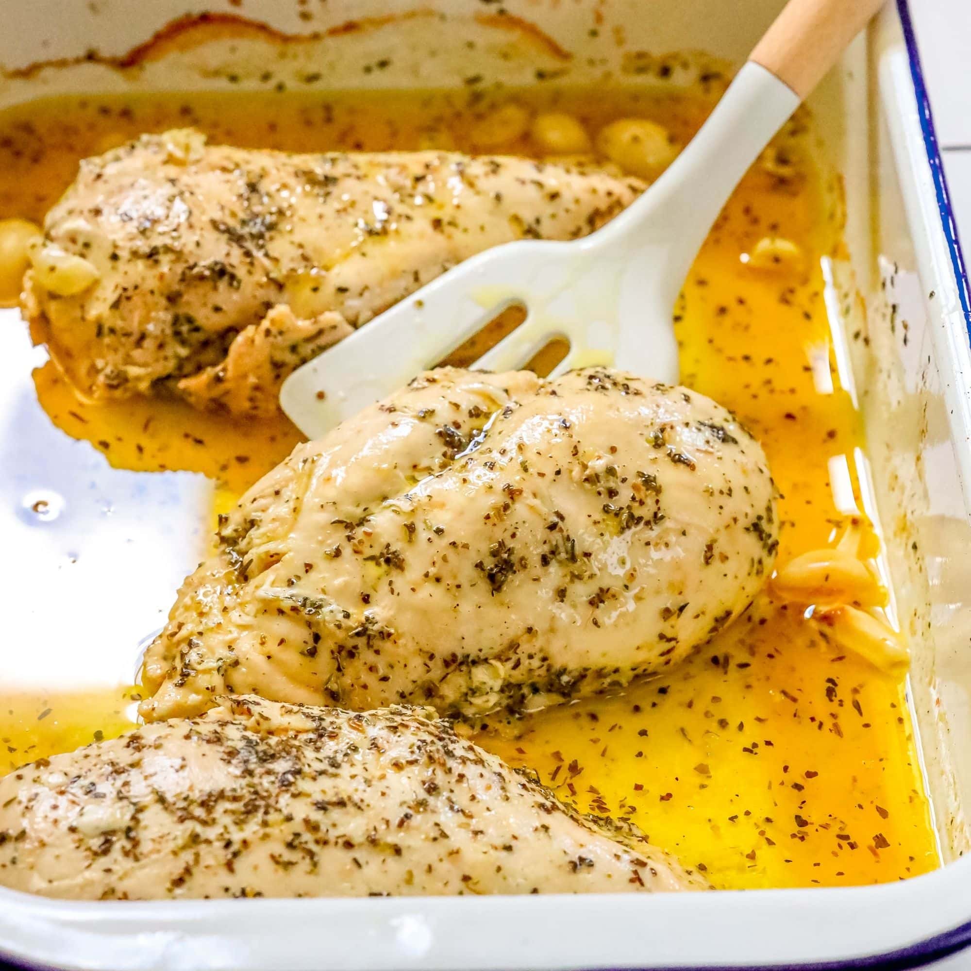 The Best Easy Baked Chicken Breasts Recipe with a spoon.