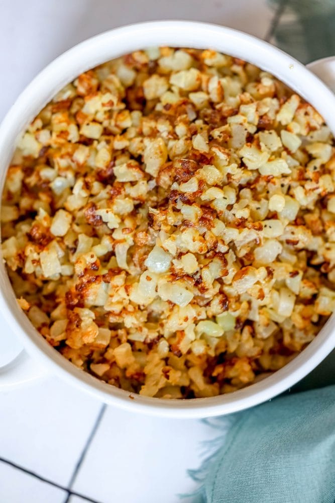 browned cauliflower rice in a white bowl.