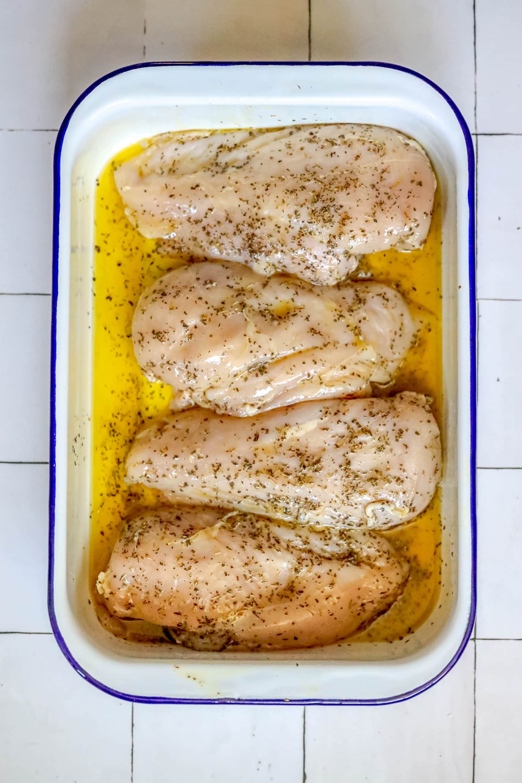 Chicken breasts in a baking dish with lemon and garlic.