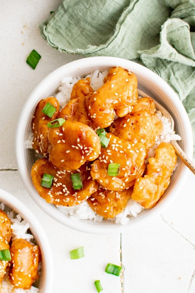 picture of sesame chicken in a bowl over rice