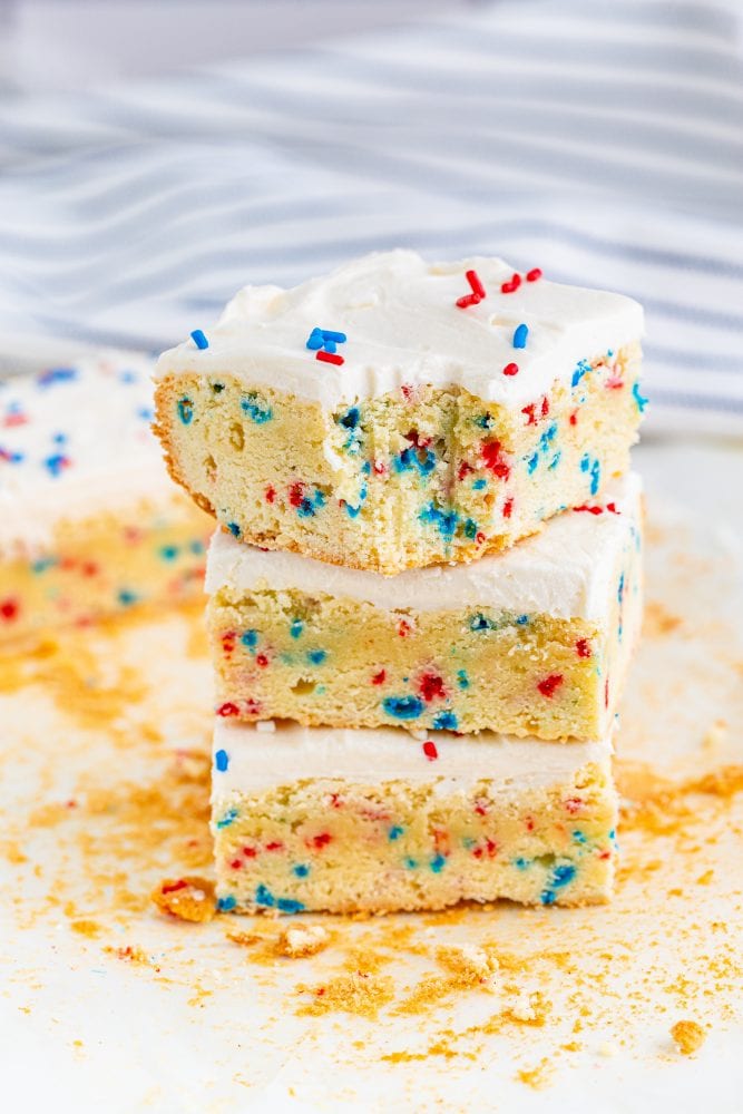 three vanilla bars with red and blue sprinkles in them and on frosting on top