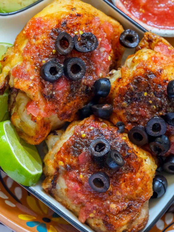 picture of air fryer chicken thighs with salsa and sliced olives on top