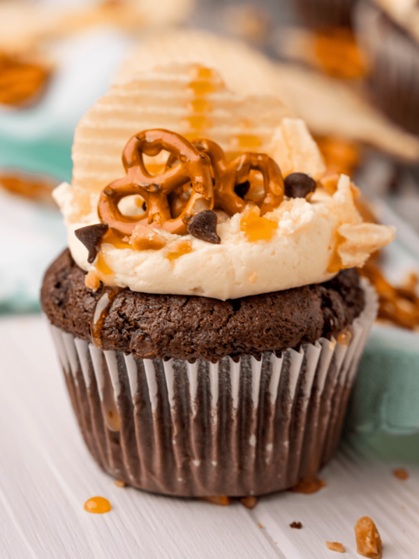 picture of cupcake topped with chips pretzels chocolate chips and caramel sauce
