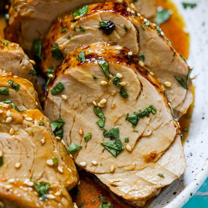 picture of sliced pork tenderloin in teriyaki sauce with sesame seeds on top