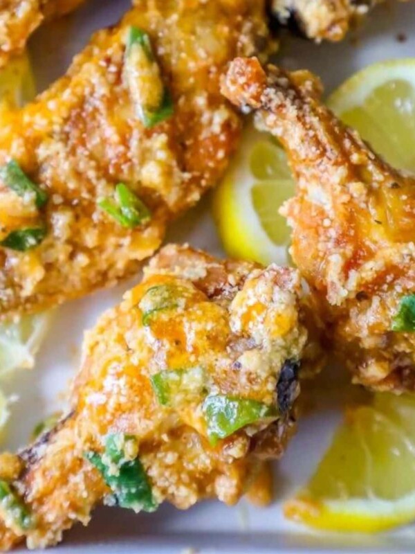 picture of lemon garlic parmesan chicken wings on a plate with lemon slices