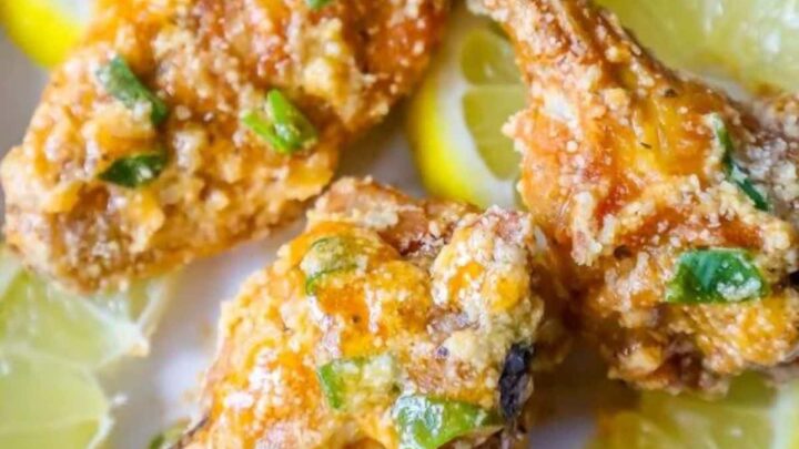 picture of lemon garlic parmesan chicken wings on a plate with lemon slices