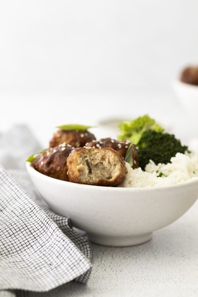 bowl with rice, broccoli, and sticky meatballs with sesame seeds