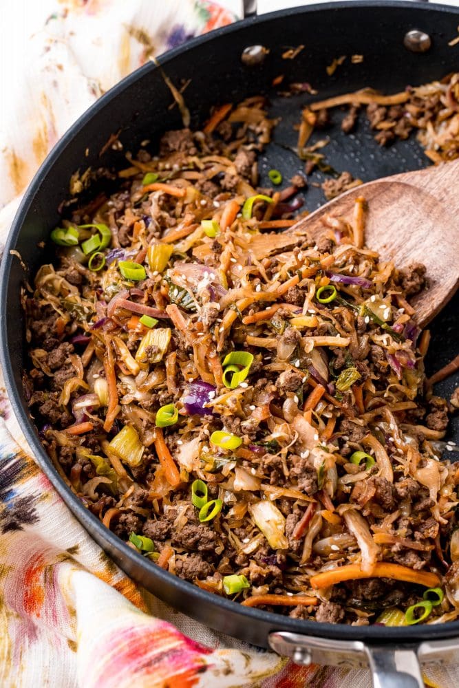 picture of egg roll stir fry in a skillet with bok choy in the background