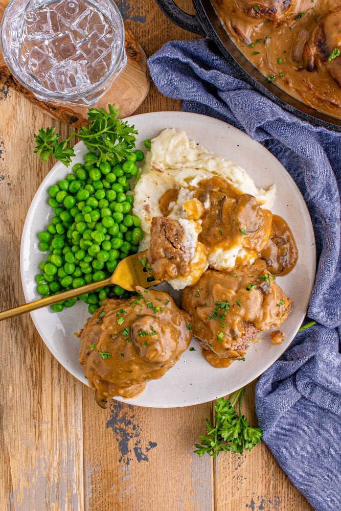 breaded steak with brown gravy and mashed potatoes on the side