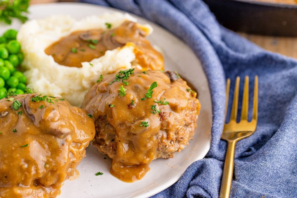 breaded steak with brown gravy and mashed potatoes on the side