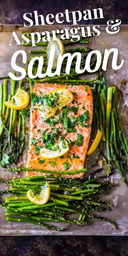 picture of salmon and asparagus on a baking sheet with lemons and parsley on top of it