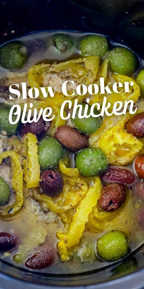 picture of chicken breasts in slow cooker with olives and banana peppers on top 