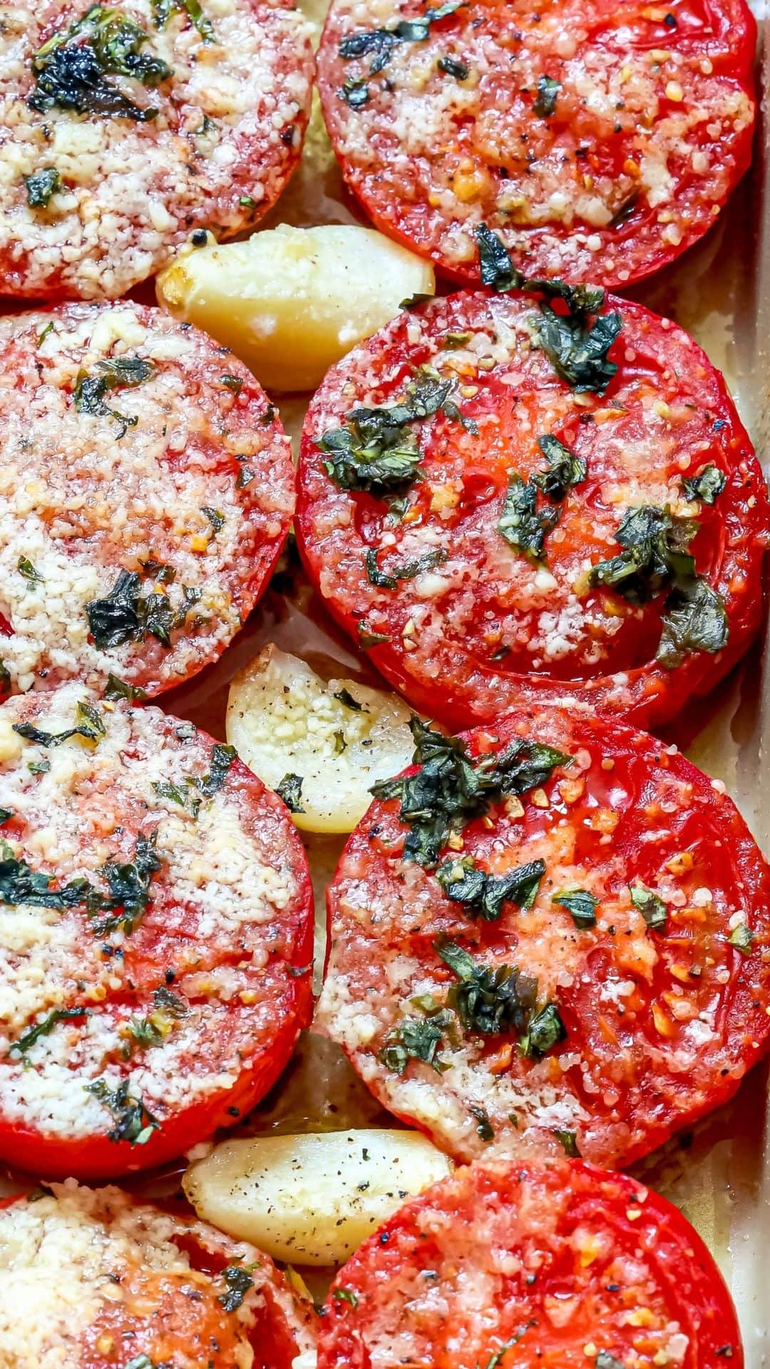 tomatoes in a casserole dish with garlic, basil, and parmesan cheese