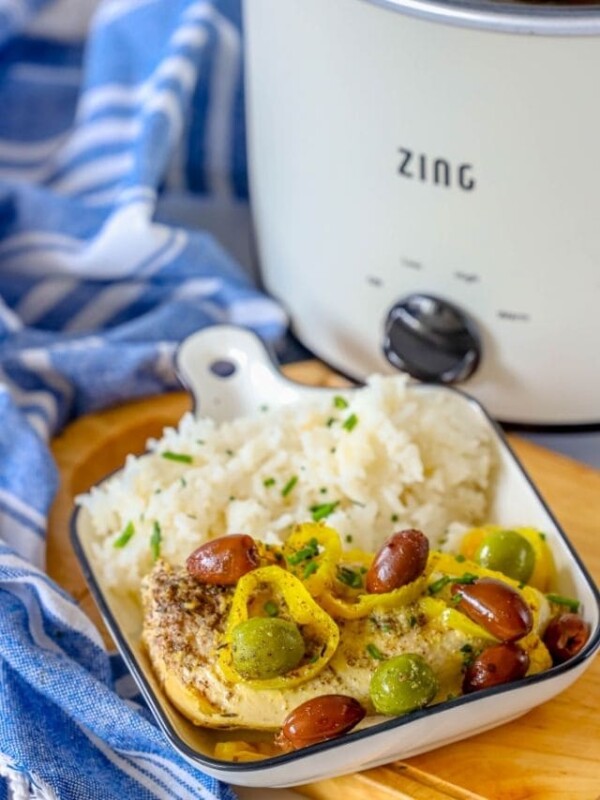 A slow cooker with rice and olives in front