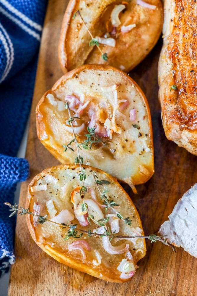 roasted pears on a cutting board with shallots and rosemary