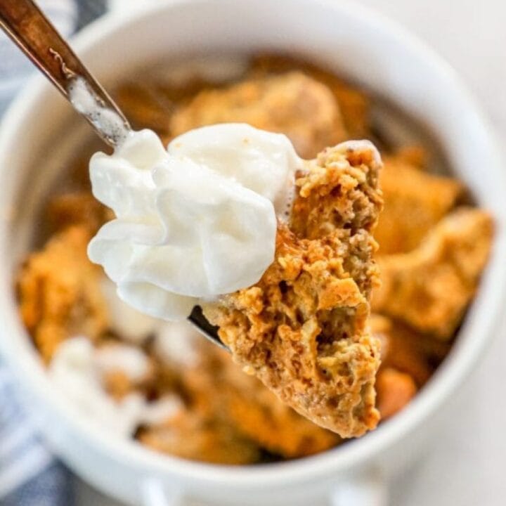 picture of keto bread pudding with whipped cream on a spoon