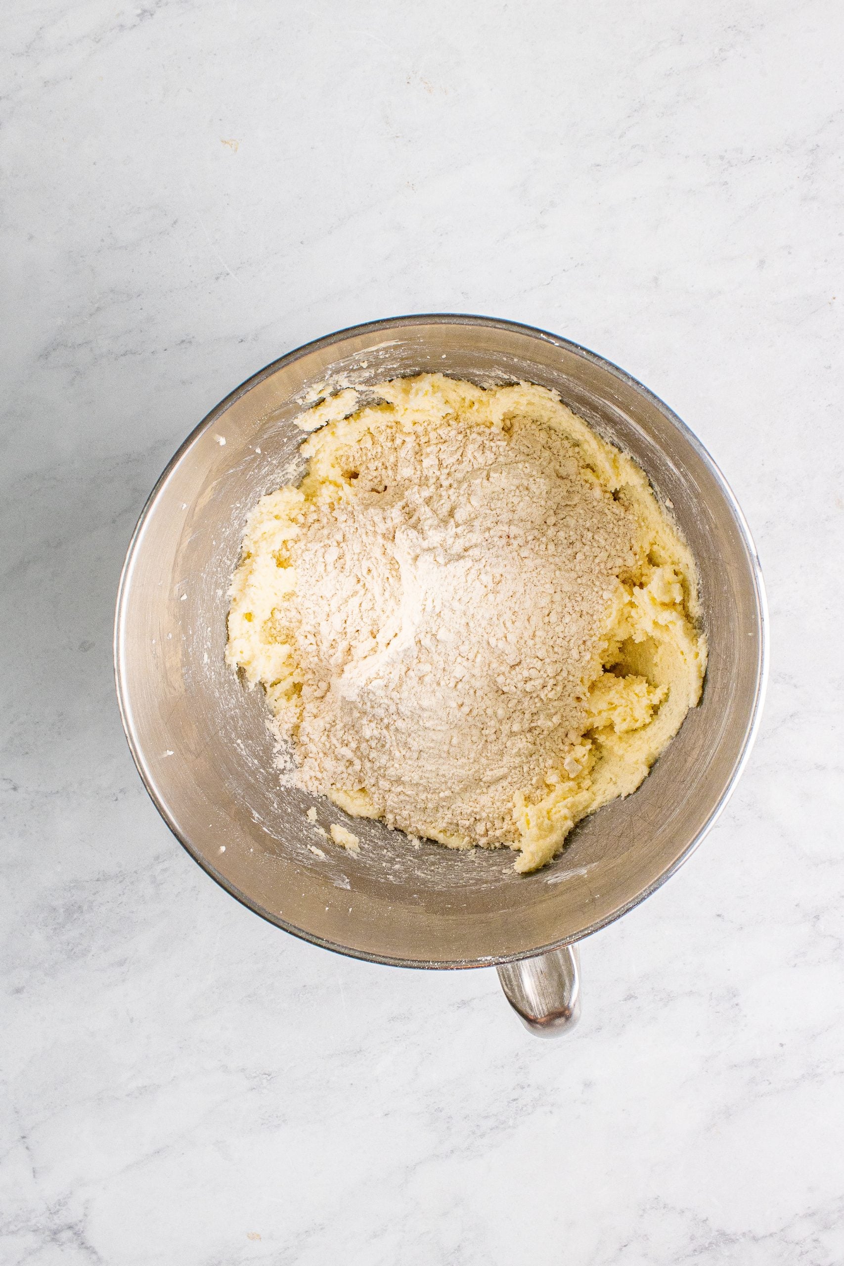 A metal mixing bowl with edible pumpkin chocolate chip cookie dough.
