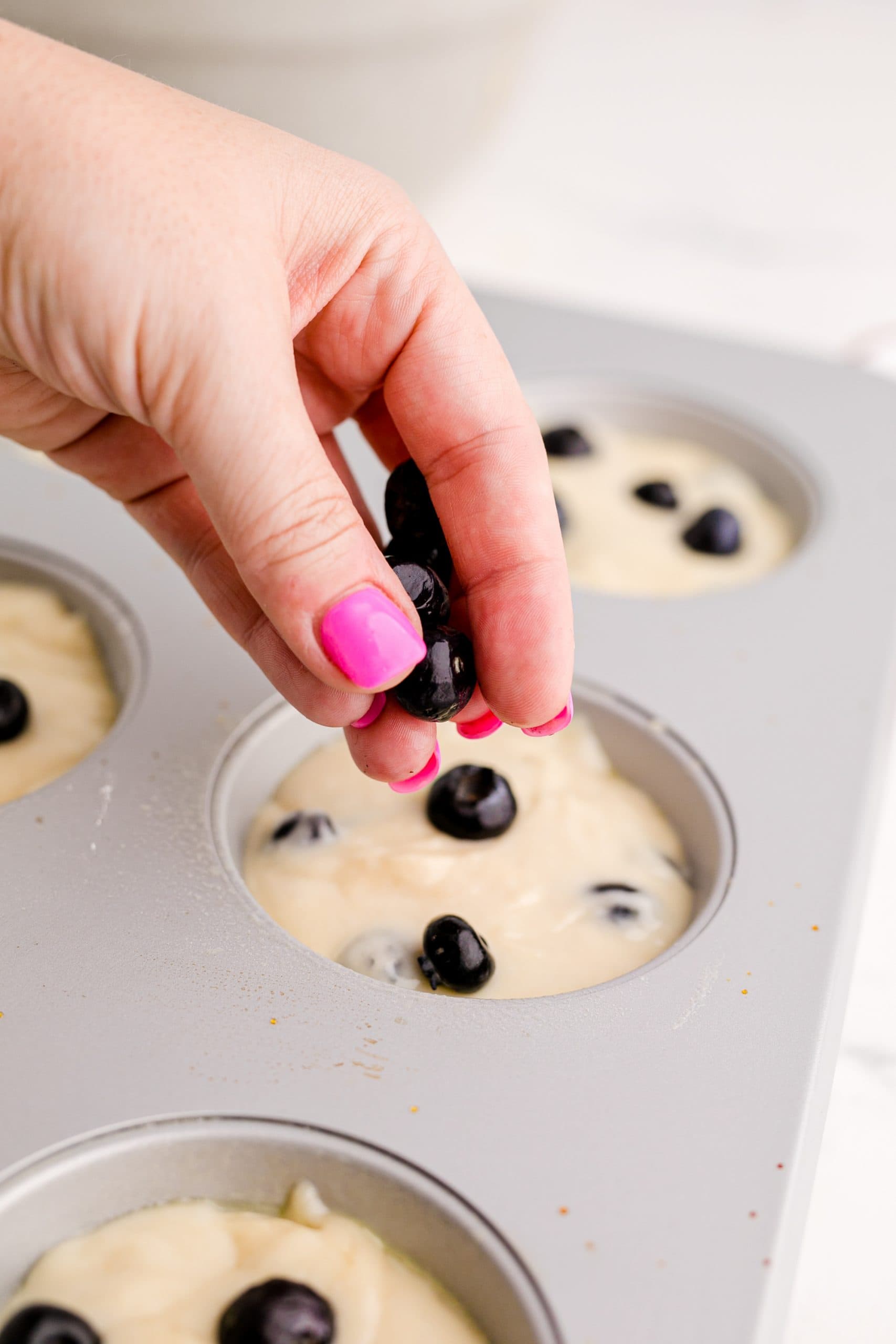 A person making Blueberry Muffins.
