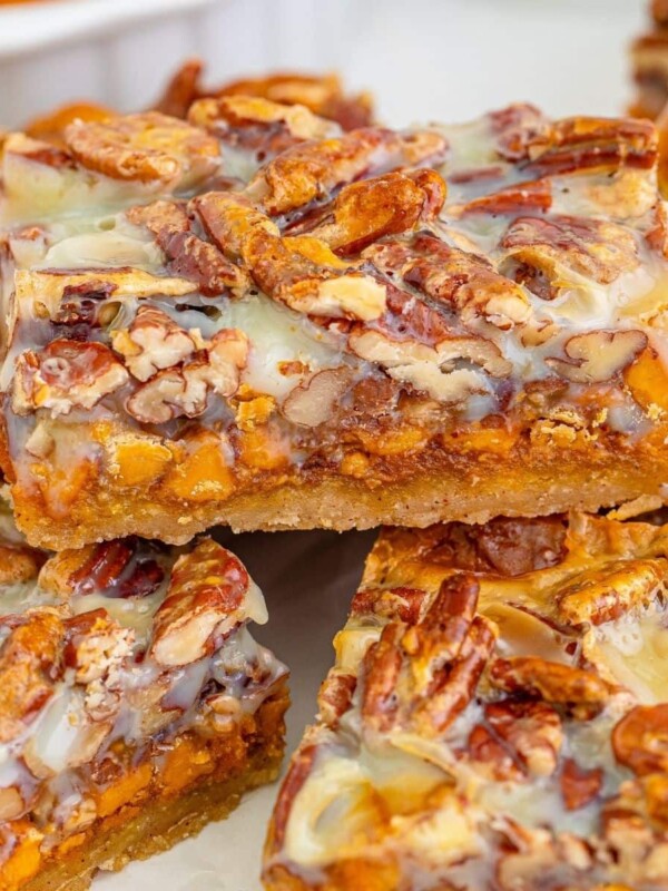 picture of pumpkin cookie bars with pecans and glaze stackes on top of each other on a table