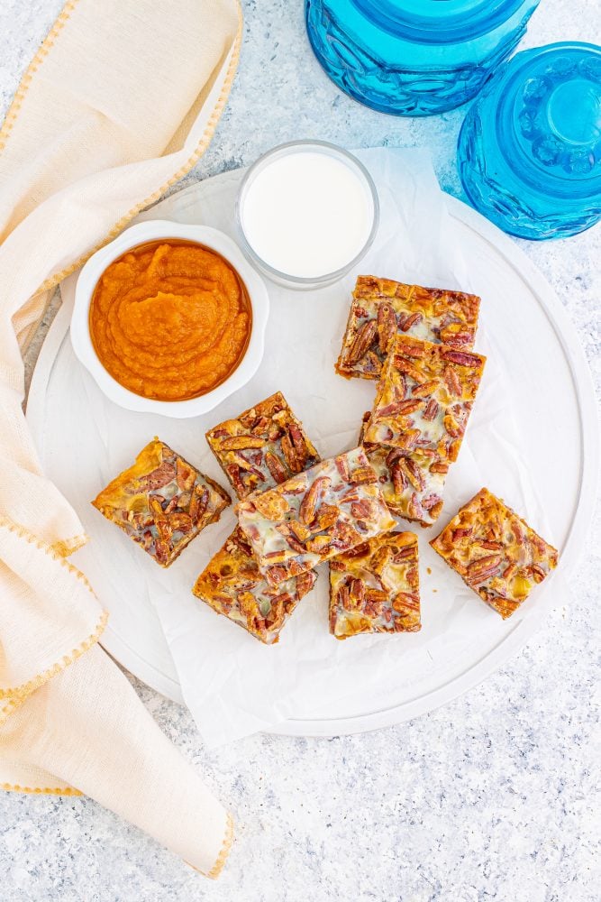 picture of pumpkin pie bars with pecans and a cookie base stacked together on a table