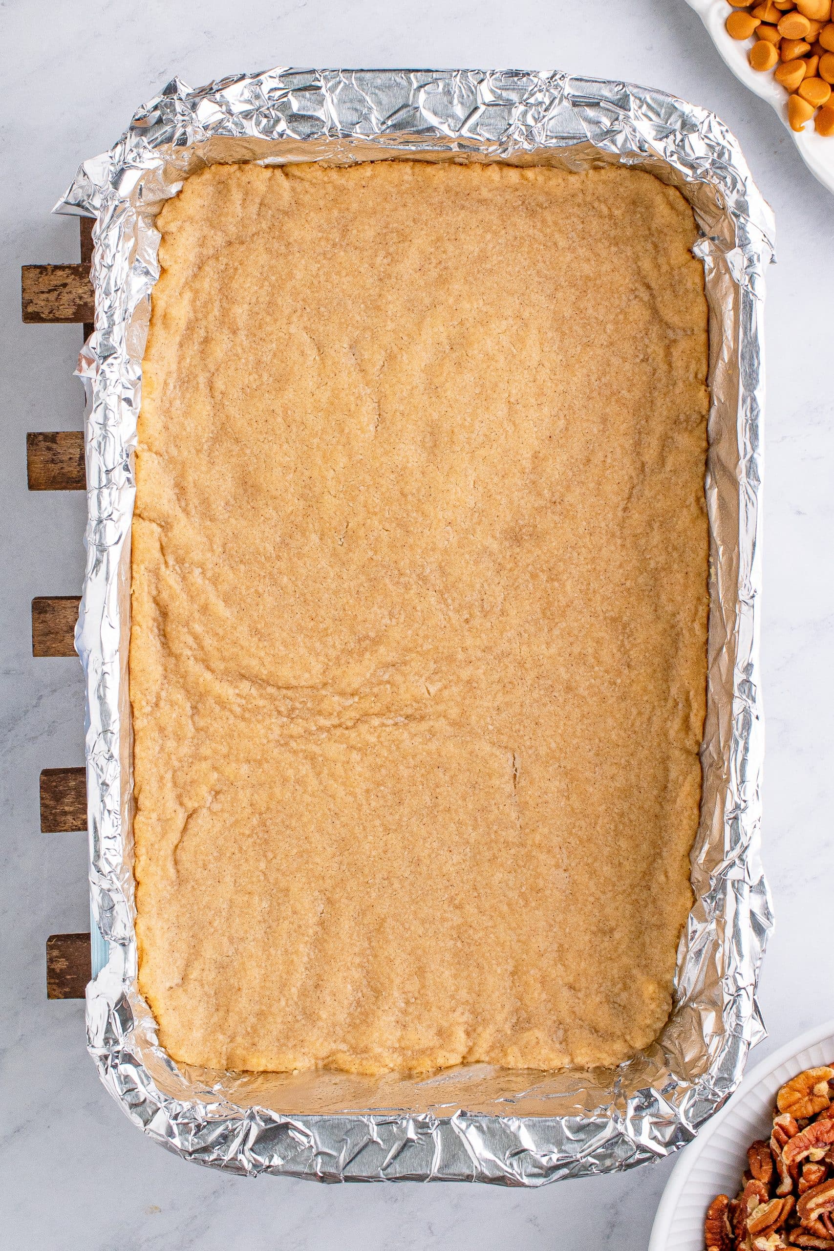picture of cookie dough baked into a pan lined in foil