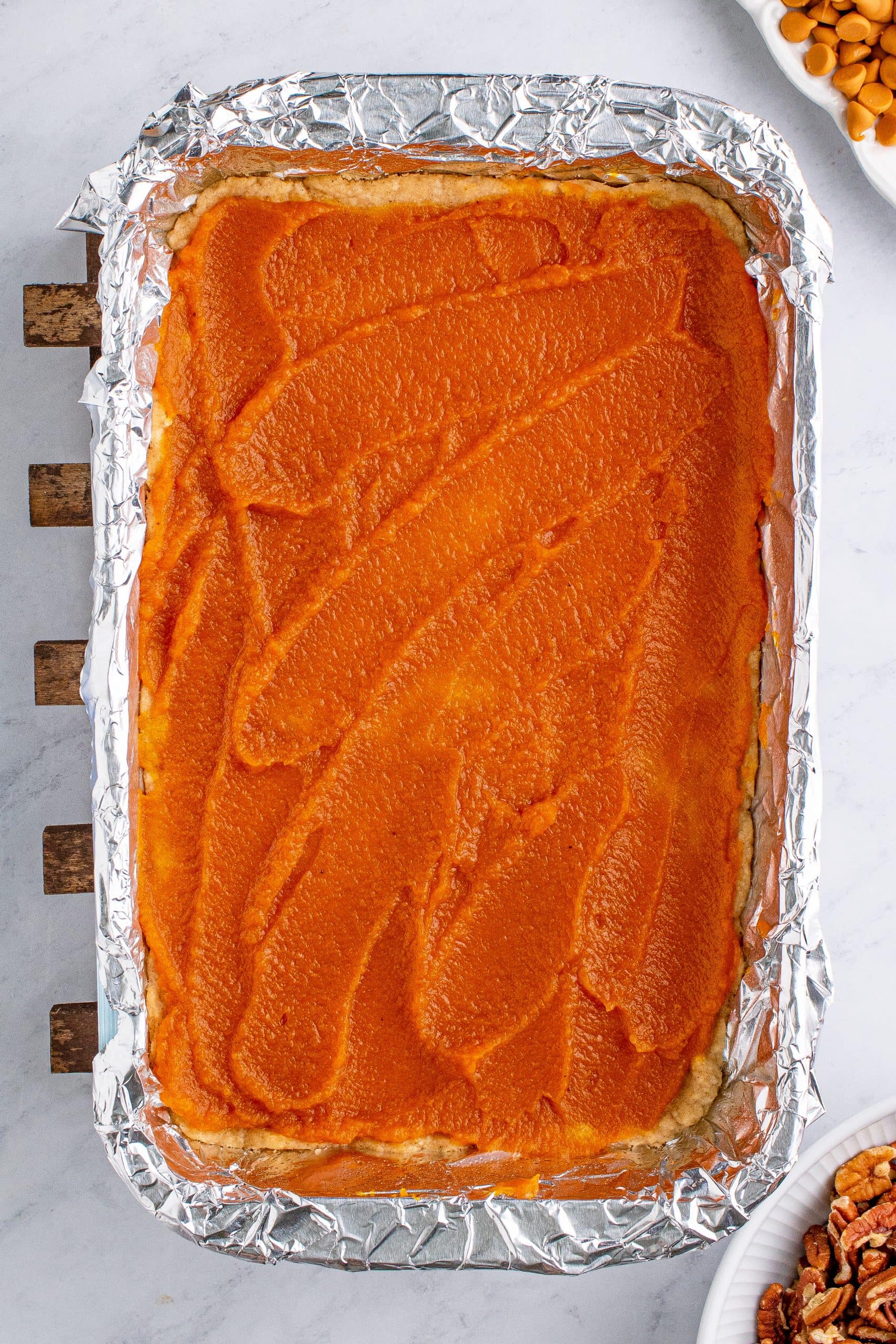 A casserole dish of sweet potato topped with nuts.