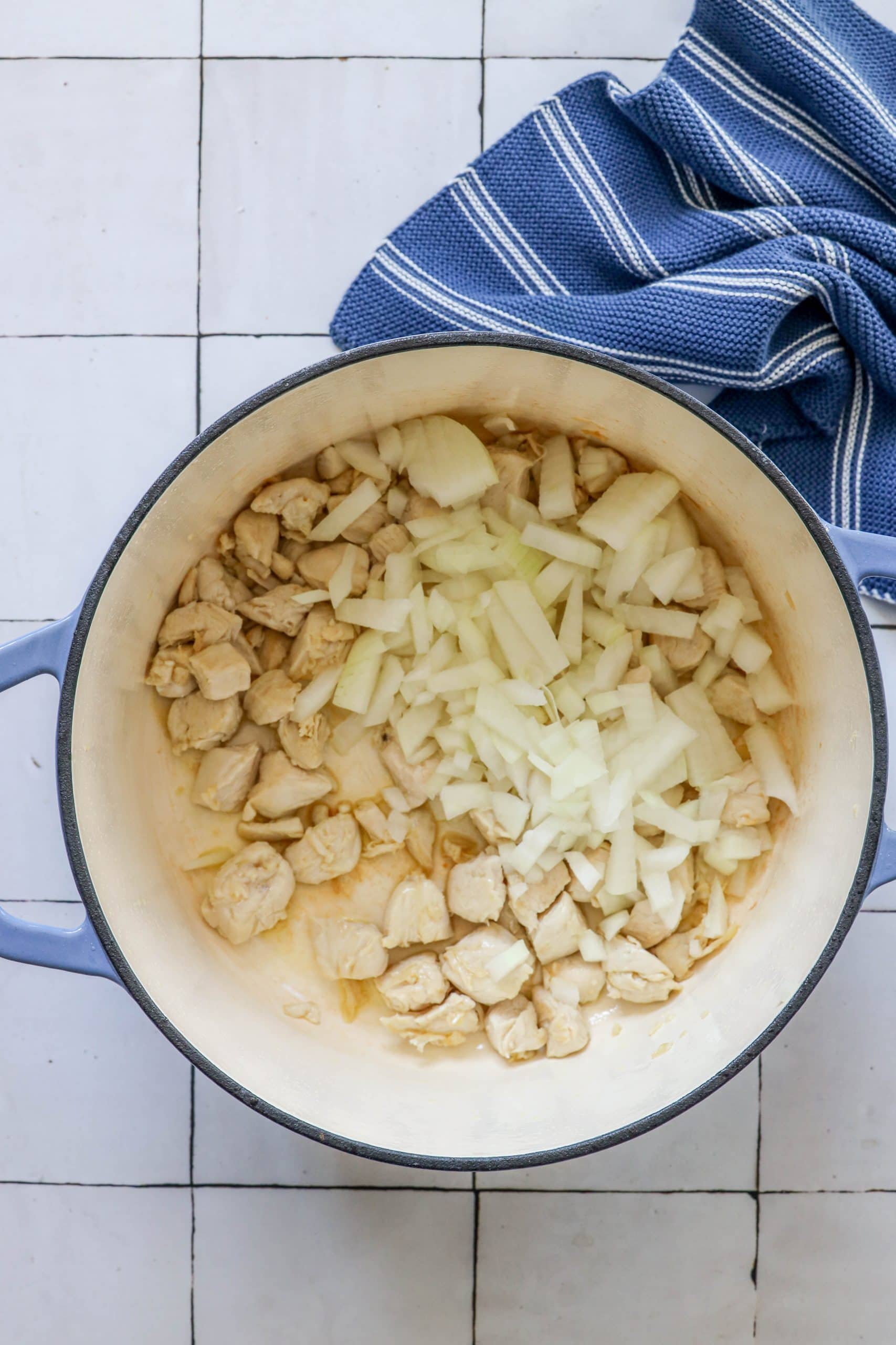 picture of diced chicken and onions in a dutch oven pan