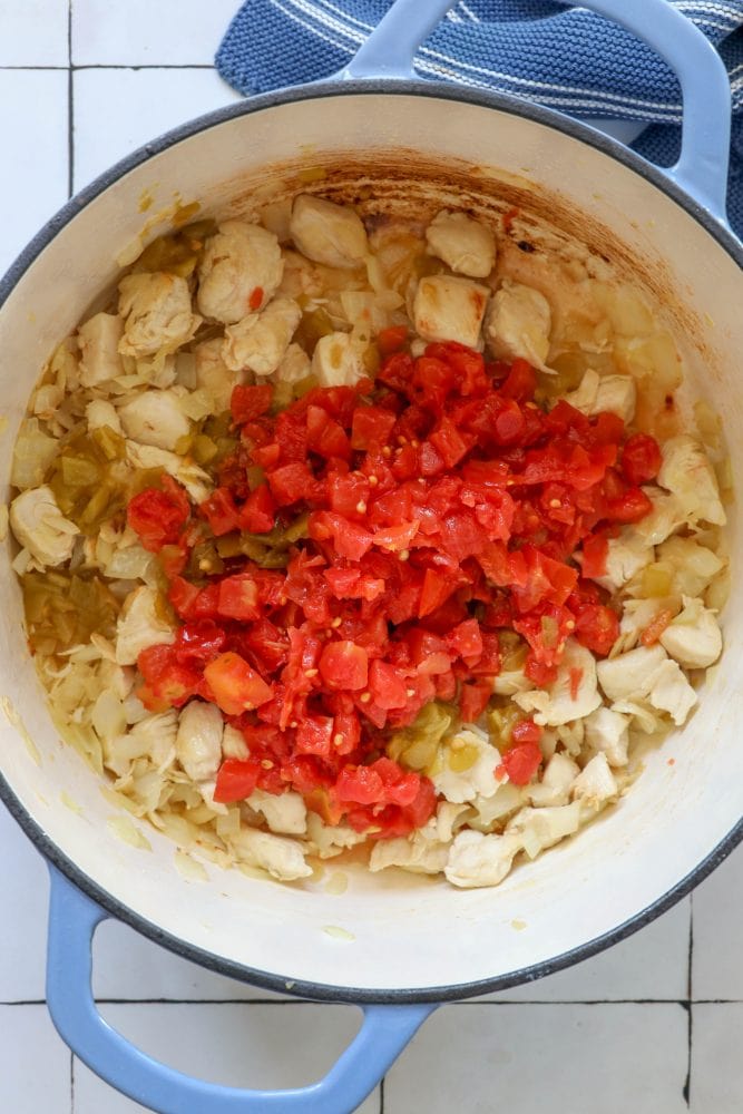 picture of diced chicken, ro-tel, green chilies and browned onions in a dutch oven pan